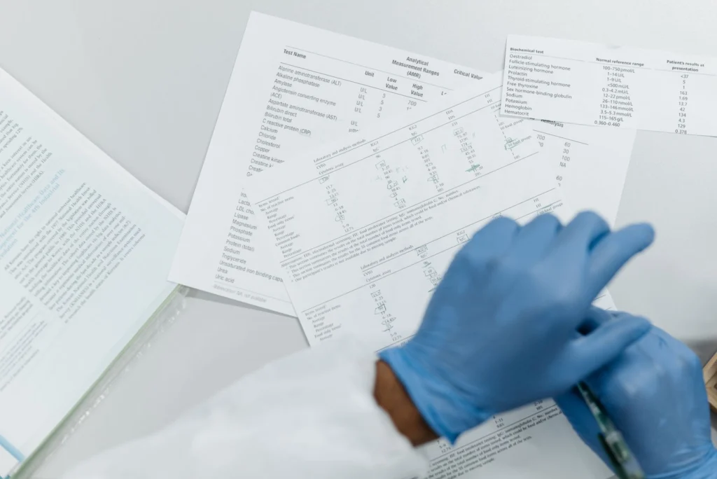 Gloved hands reviewing an analytical Certificate of Analysis document