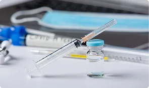 Research syringe and sample vial on a laboratory surface, representing GLP-1 and metabolic research articles