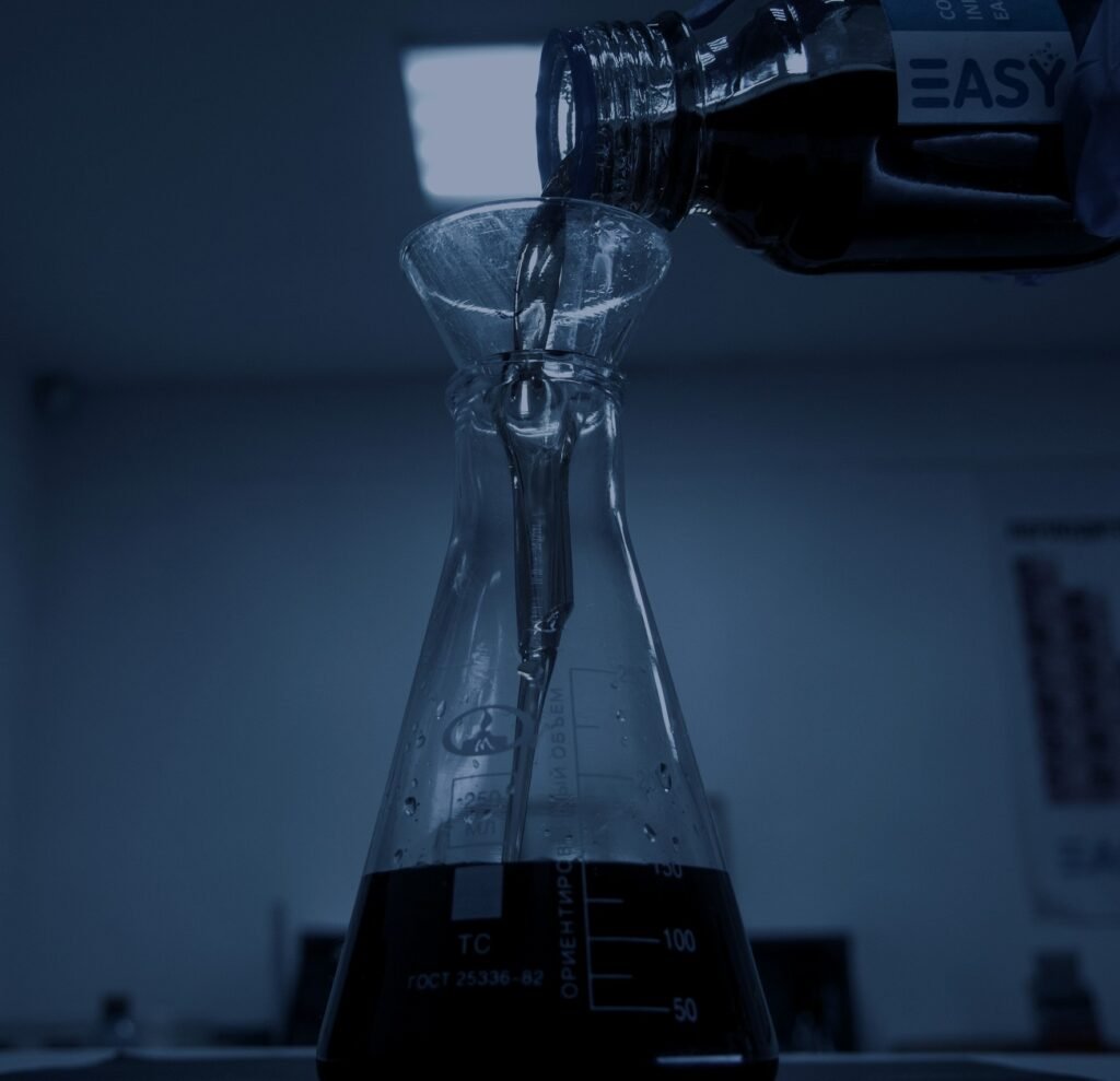 Liquid being poured into a laboratory flask – PerformanceLabs UK